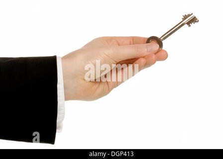 Business man hand holding a safe key, symbolic image for key skills Stock Photo