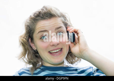 Young woman with bright blue eyes speaking on her mobile phone, portrait Stock Photo