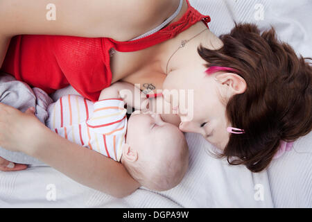 Mother holding her sleeping baby in her arms Stock Photo