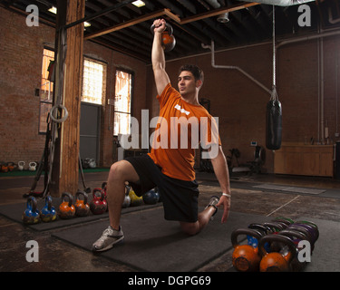 Bodybuilder using kettlebells in gym Stock Photo