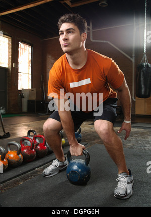 Bodybuilder lifting kettlebells in gym Stock Photo
