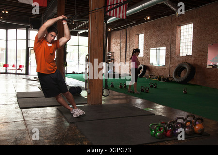 Bodybuilder using rings in gym Stock Photo