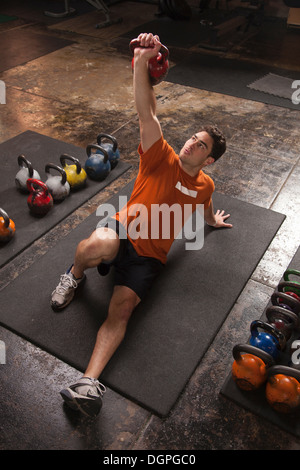 Bodybuilder lifting kettlebell in gym Stock Photo