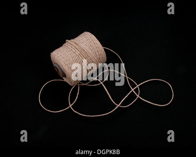 Ball of string or twine on a plain black background. Stock Photo