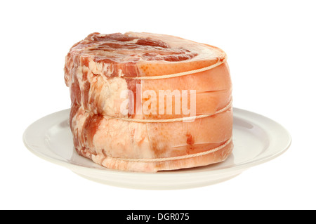 Low angle shot of a raw joint of pork on a plate isolated against white Stock Photo