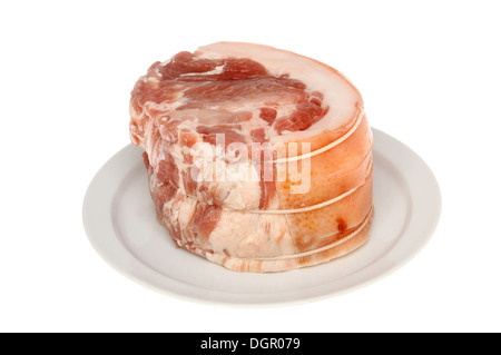 Raw joint of rolled shoulder of pork on a plate isolated against white Stock Photo