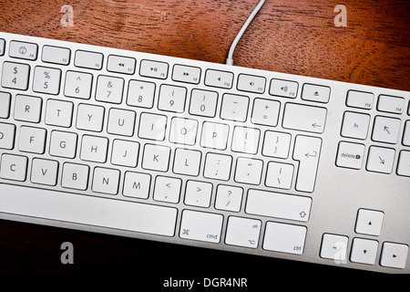 Close up of a white keyboard on a wooden desk Stock Photo