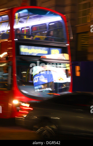Motion blurred image of red London Bus with lights of Piccadilly reflected Stock Photo