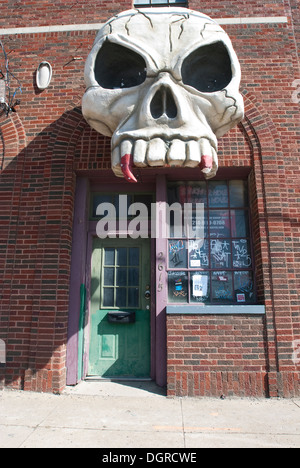 Giant Skull above the entrance to a haunted house set in a warehouse district. Stock Photo