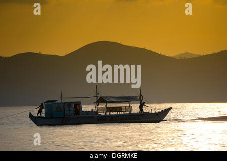 Banka, a traditional Filipino outrigger boat, anchored off the beach in the evening light, Busuanga, Philippines, Asia Stock Photo