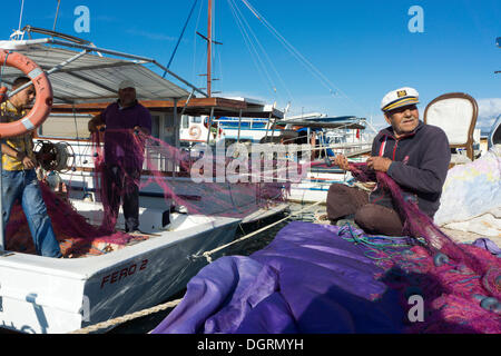 Zeytineli Köyü, harbour with fishing boats, fishermen repairing a net, Ilica, Izmir Region, Turkey, Asia Stock Photo