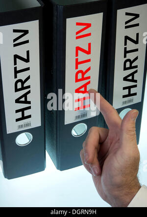 Hand pointing to a ring binder labeled Hartz IV, German term for long-term unemployment benefits, symbolic image Stock Photo