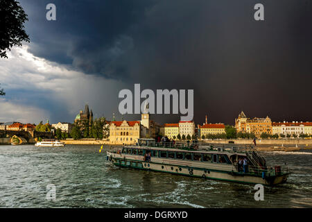 View over the Vltava river towards a thunderstorm, Bedrich Smetana Museum at the rear, Charles Bridge, former waterworks, Old Stock Photo