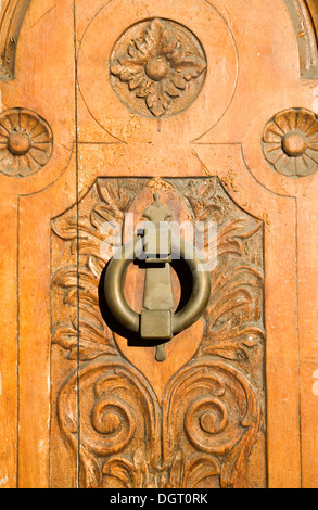 Ornate decorated wooden door with brass knocker  in the old city Ronda, Spain Stock Photo