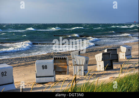 Beach chairs on the beach with a rough Baltic Sea, near Ahrenshoop, stormy weather, Ahrenshoop, Darss Stock Photo