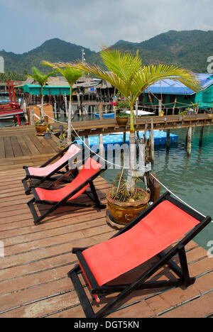 Red deck chairs on the pier in the Bang Bao bay, Koh Chang Island, National Park Mu Ko Chang, Trat, Gulf of Thailand, Thailand Stock Photo