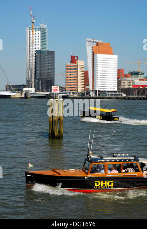 Small watertaxi ferry boats on the Nieuwe Maas River, modern architecture at the Wilhelminapier at back, Rotterdam, Zuid-Holland Stock Photo