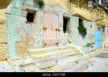 Steps leading up to a room inside the rocks, pastel colours in the harbour area, Marsalforn Bay, Marsalforn, Island of Gozo Stock Photo