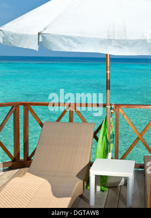 Parasol and chaise lounge on a terrace Stock Photo