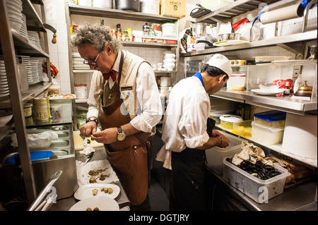 People working in a small professional kitchen, La Mascareta restaurant, Venice, Italy. Stock Photo