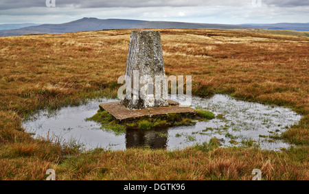 Moated Ordnance Survey trig point on the summit of Fan Gyhirych in the central Brecon Beacons looking towards Pen y Fan Stock Photo