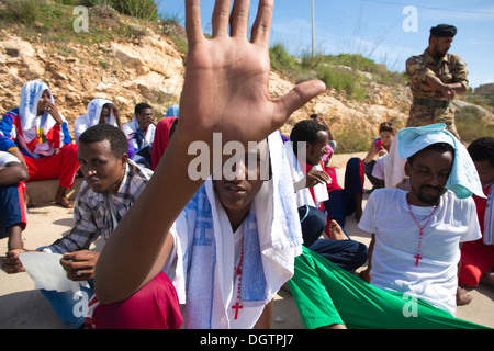Eritrean migrants rescued from the sea near Lampedusa, Italy gather to prayer for lost relatives during a silent protest. Stock Photo