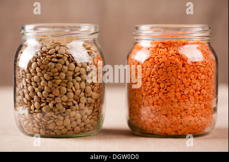 Red and green lentils seeds in glass jars Stock Photo