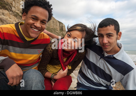 Three teenage friends on a beach, Hastings, East Sussex, UK Stock Photo