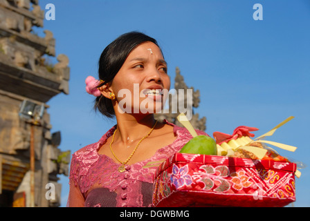 Balinese Hinduism, devout woman carrying an offering bowl with gifts, Pura Ulun Danu Batur temple, Batur village, Bali Stock Photo