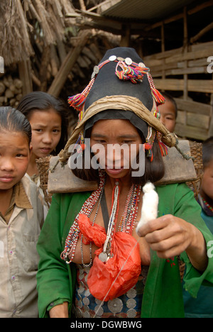 Portrait of a young woman of the Akha Eupa ethnic group concentrating on spinning cotton, wearing traditional clothes and a Stock Photo