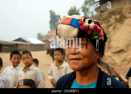 Portrait of a woman of the Phoussang ethnic group wearing traditional costume and colourful pompon hat with children Stock Photo