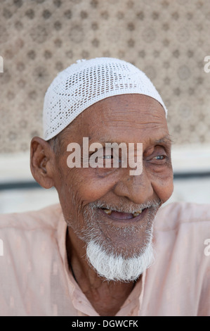 Islam, portrait, Muslim, old man with a beard wearing a cap, sitting in front of the Tomb of Sheikh Salim Chishti Stock Photo