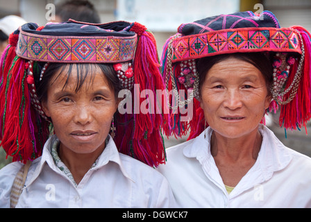 Two women of the Yi or Hani ethnic minority wearing colourful headware at a festival, portrait, Jiangcheng, Pu'er City