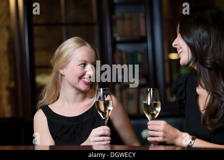 two beautiful women friends spending their evening in an elegant nightclub Stock Photo