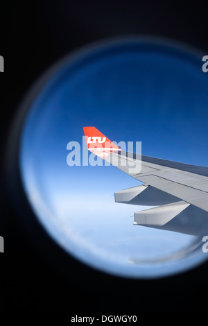 View from the cabin window to the wing of an Airbus aircraft in flight, with winglet and the logo of airline LTU Stock Photo