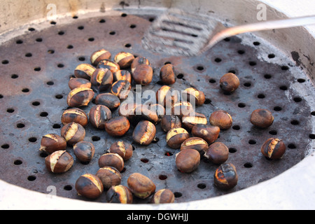 Roasted chestnuts delicious autumn fruit at street vendor Stock Photo