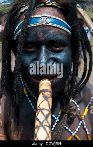 Black painted and decorated man during the traditional Sing Sing in the highlands, Enga, Highlands, Papua New Guinea Stock Photo