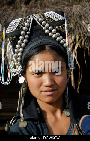 Portrait, woman of the the Akha Nuqui ethnic group, traditional costume, headdress, cap decorated with silver beads Stock Photo