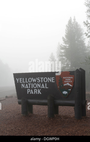 Entrance, wooden sign in the fog, National Park Service, west entrance, Yellowstone National Park, West Yellowstone, Montana Stock Photo