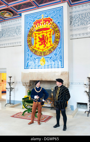 Drama, two men wearing medieval clothes, old coat of arms of the Kings of Scotland in Stirling Castle Palace, Stirling, Scotland Stock Photo