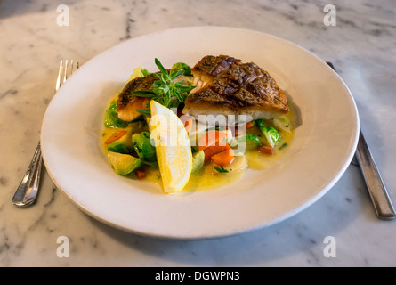 Grilled Chilean sea bass cooked with vegetables and a lemon slice Stock Photo