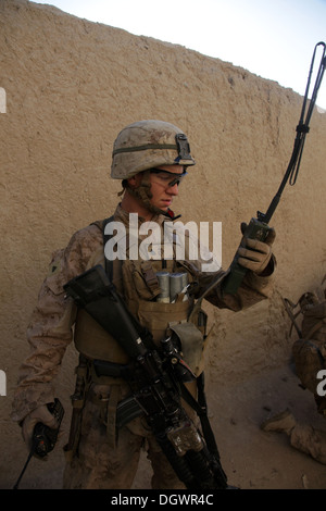 A U.S. Marine with India Company, 3rd Battalion, 7th Marine Regiment (3/7), checks a radio during a patrol near Forward Operating Base Musa Qala, Helmand province, Afghanistan, Oct. 20, 2013. The Marines with 3/7 patrolledled to reduce enemy activity in t Stock Photo