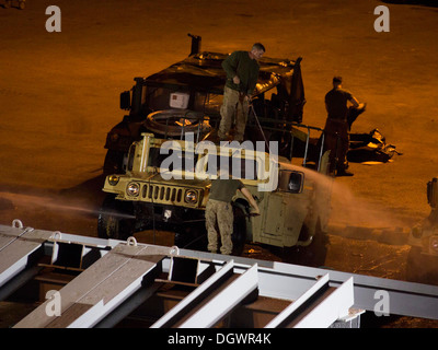 U.S. Marines and Sailors assigned to the 26th Marine Expeditionary Unit (MEU) clean a Humvee during the 26th MEU's wash down aboard Naval Station Rota, Spain, Oct. 20, 2013. The 26th MEU is a Marine Air-Ground Task Force forward-deployed to the U.S. 6th F Stock Photo