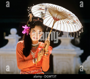 Young woman wearing a traditional silk robe, with a paper umbrella, Mandalay, Mandalay Division, Myanmar, Burma Stock Photo