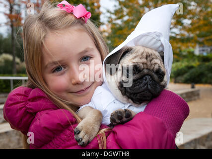 Manchester, UK 26th October, 2013. Libby McCoy, 7 years old from Chorley, with her puppy pug Nigel in costume, at the Quays, Trafford Park, Manchester Open Weekend. Stock Photo