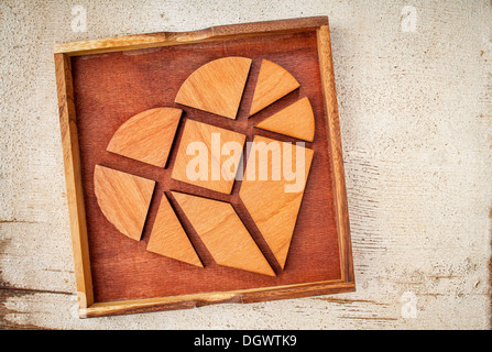 broken heart - tangram pieces in a box, a traditional Chinese Puzzle Game made of different wood parts to build abstract figures Stock Photo