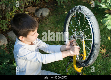 Child who fix bikes. Boy and bicycle Stock Photo