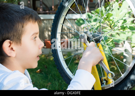 Child who fix bikes. Boy and bicycle Stock Photo