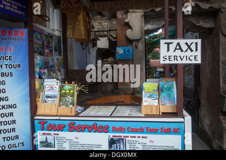 Tourist services taxi stand Ubud Bali Indonesia wooden sign offer offering offered attraction tourists prints advertise leaflets Stock Photo