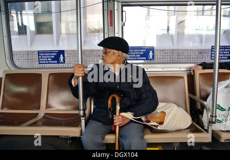 senior citizen sitting in handicapped section of muni bus in San Francisco Stock Photo